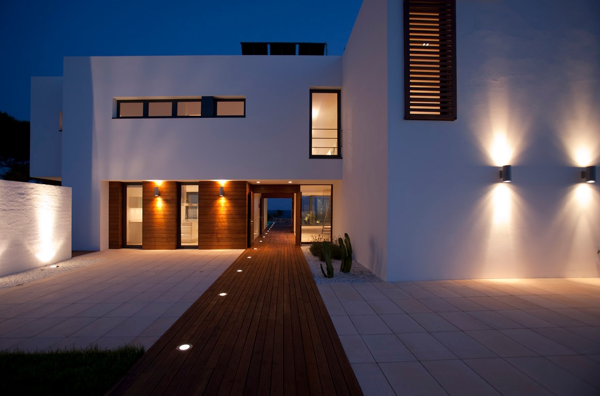 Acceso exterior iluminado de Casa Menorca al anochecer.